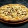 Pizza with creamy sauce, mushrooms and cheese on a black stone background. 45 degree angle view. Close-up, selective focus